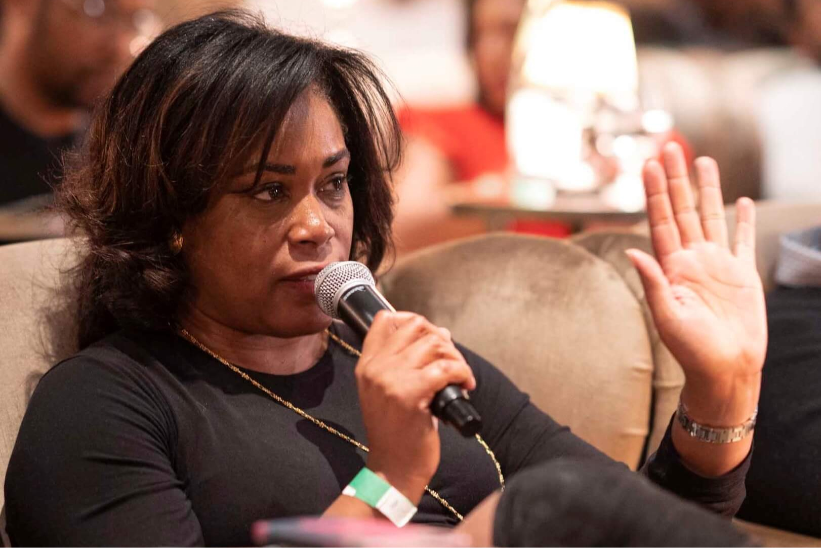 Woman speaking into a microphone while seated