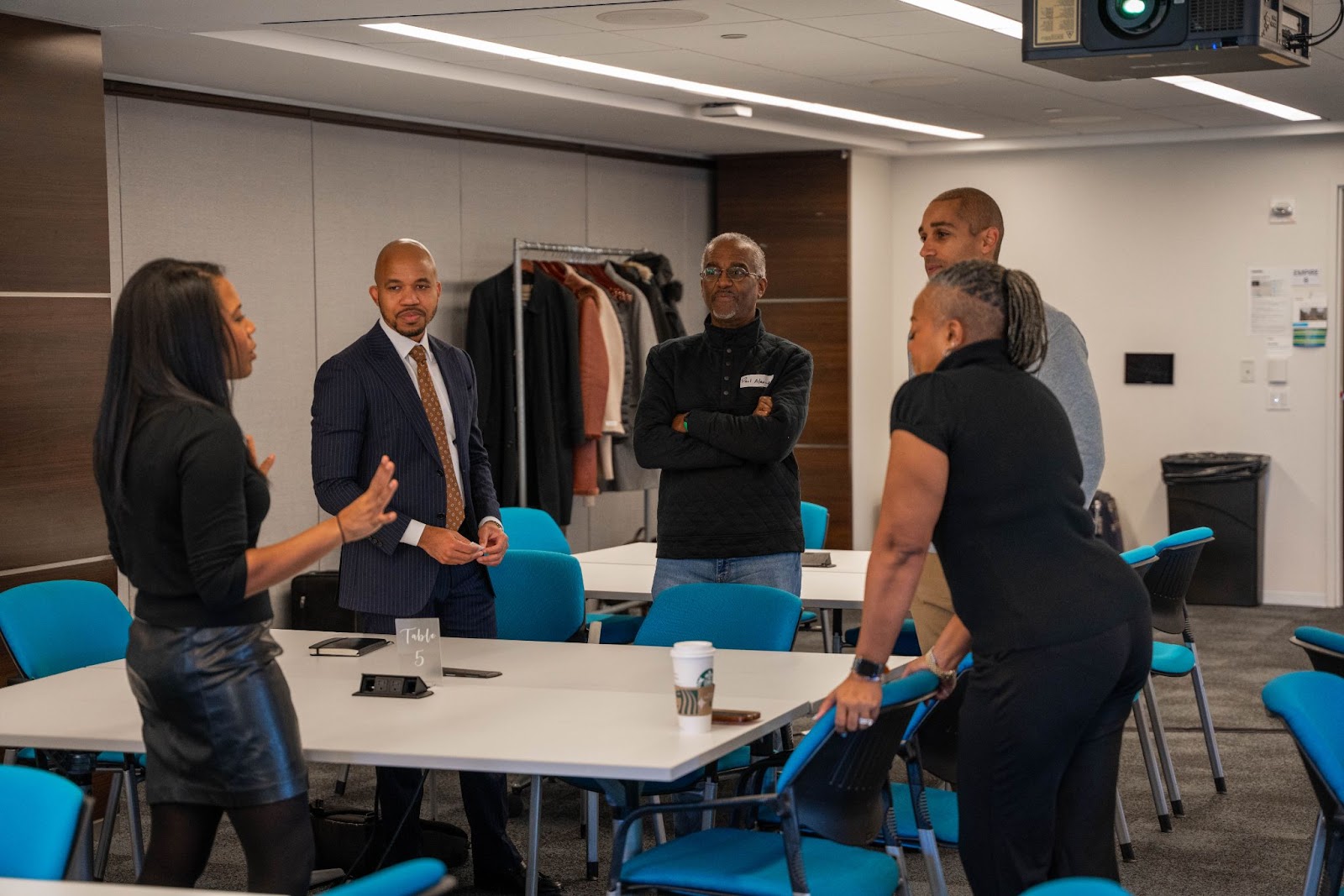 A group of professionals engaged in a discussion around a table in a conference room, with a focus on active listening and collaboration.