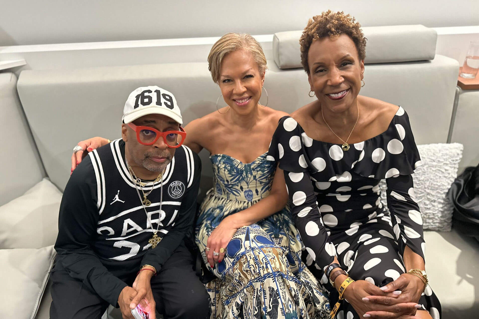 Jerri and Spike Lee sitting on a couch smiling at the camera
