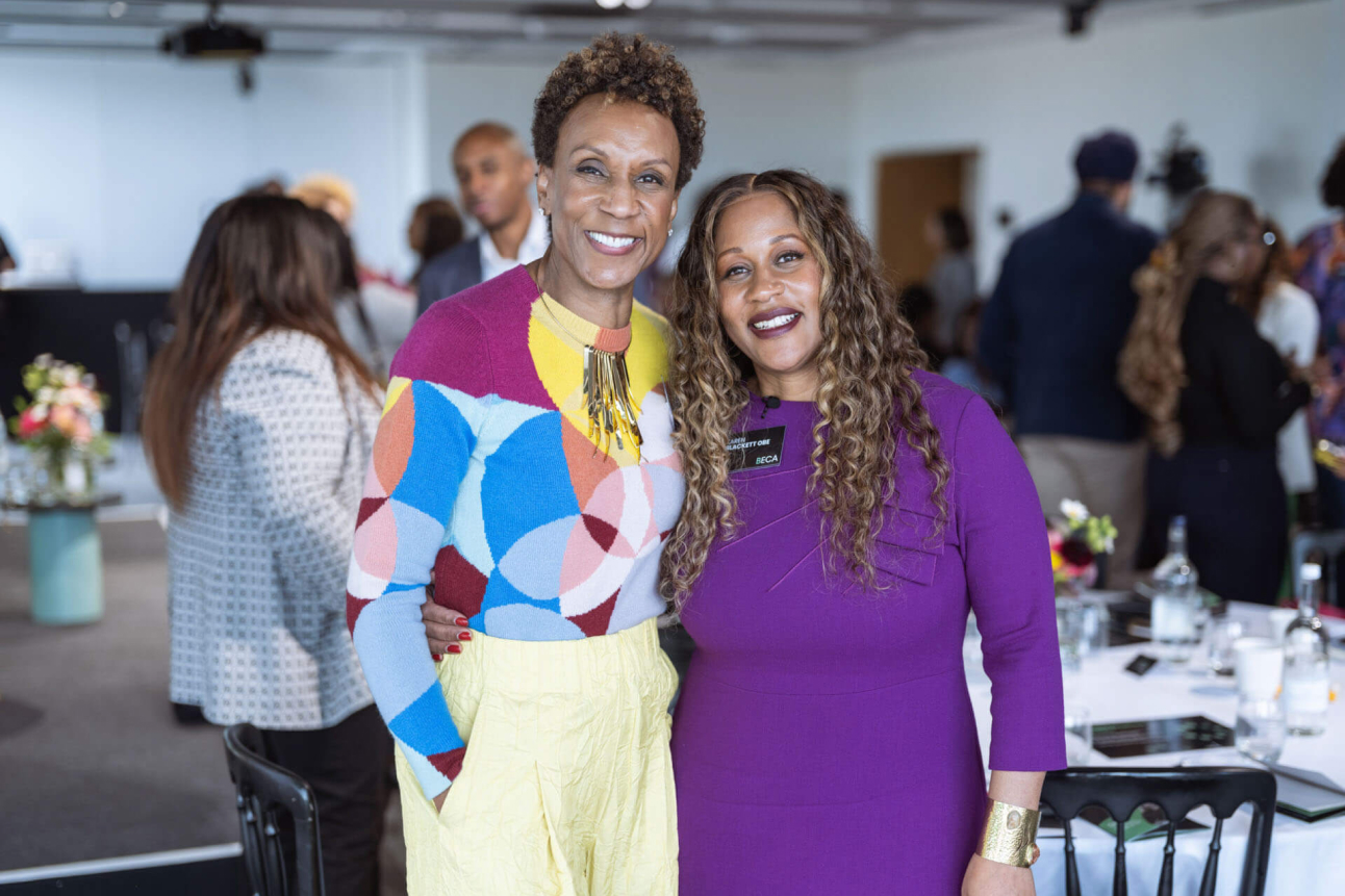 Two women smiling and posing for a phot