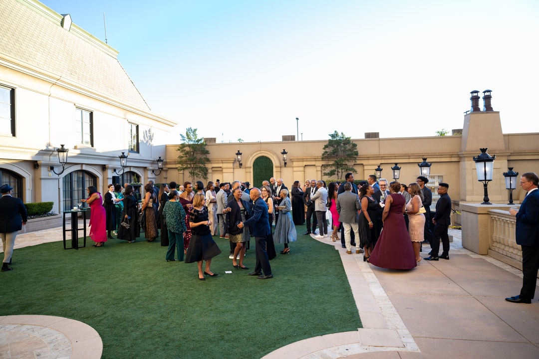 Gala attendees, elegantly dressed, walking and conversing outdoors.
