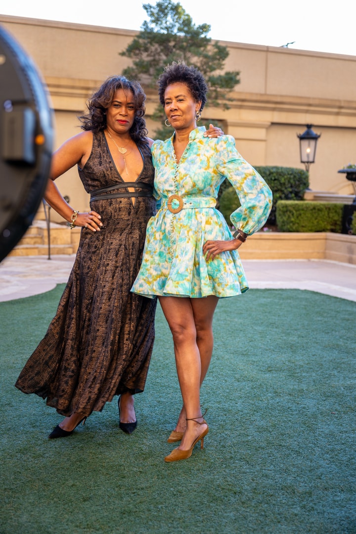 Two women, elegantly dressed posing for a photo.