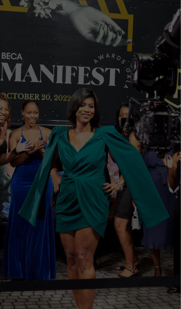 Woman in a green dress posing on the red carpet during the BECA Manifest Awards Gala.