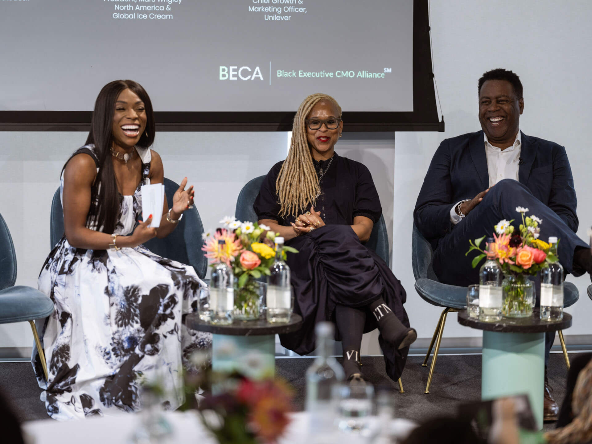 Panel discussion featuring three panelists on stage, discussing professional journeys and insights.