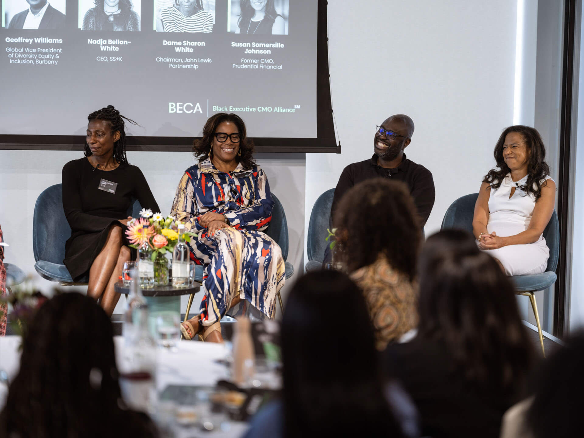 Four panelists seated on stage during a discussion on diversity, equity, and inclusion.