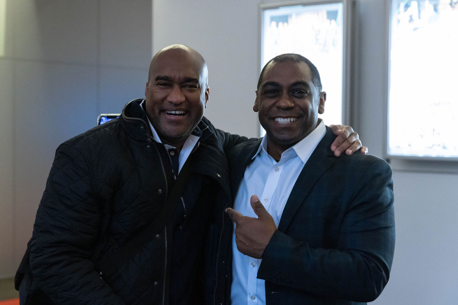 Two men smiling and posing for a friendly photograph in a bright, modern space.