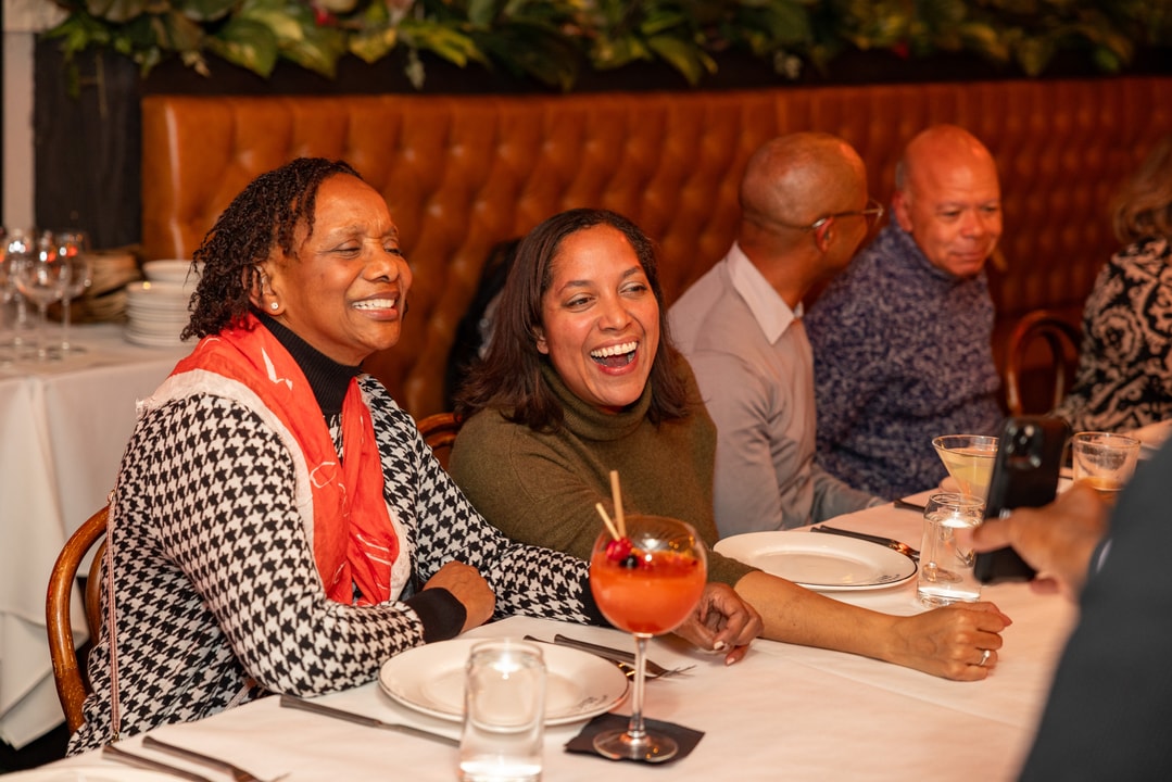 BECA Members laugh at a photo being shown to them on a mobile phone.