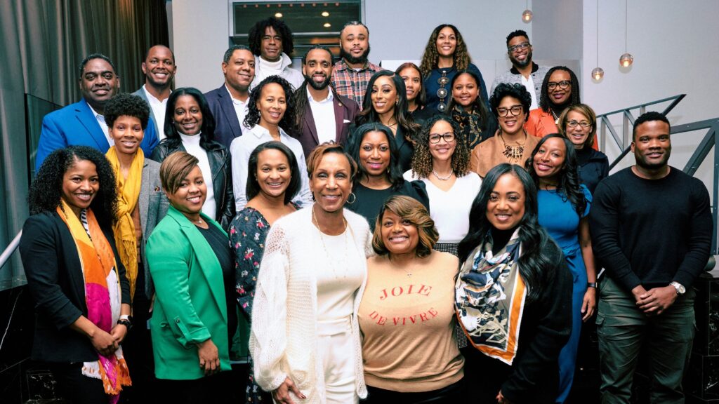 Group of festive individuals, smiling at the camera.
